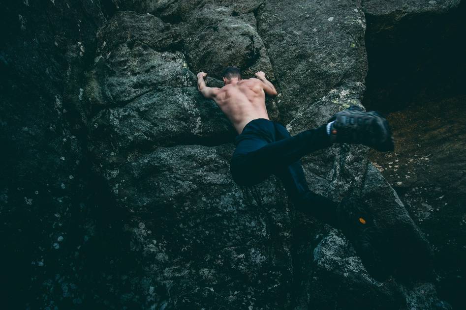 Close-up of reinforced climbing gloves on mountain terrain