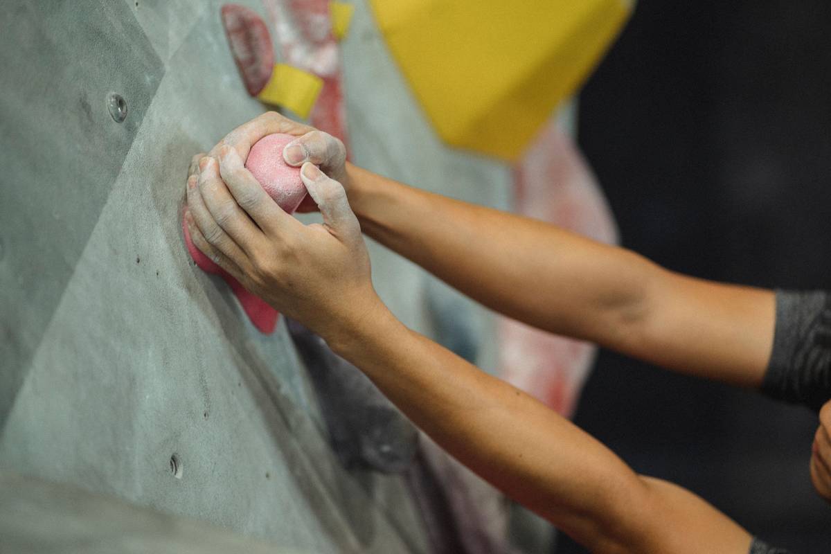 Side-by-side comparison of climbing glove palm materials on wet granite, dry sandstone, and icy basalt showing grip performance differences