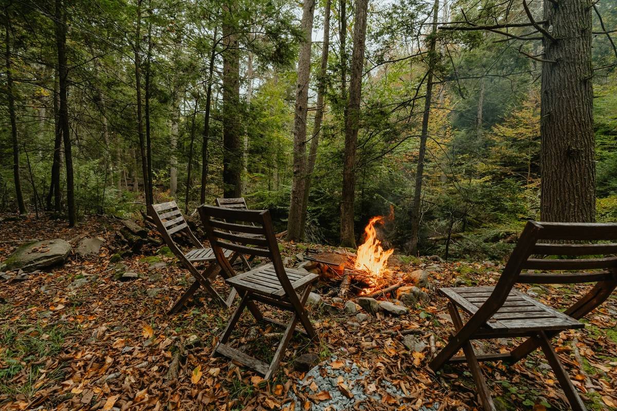 Comparison chart showing durability ratings for fire pit furniture materials: teak (9/10), powder-coated aluminum (8.5/10), all-weather wicker (7/10), untreated pine (3/10)