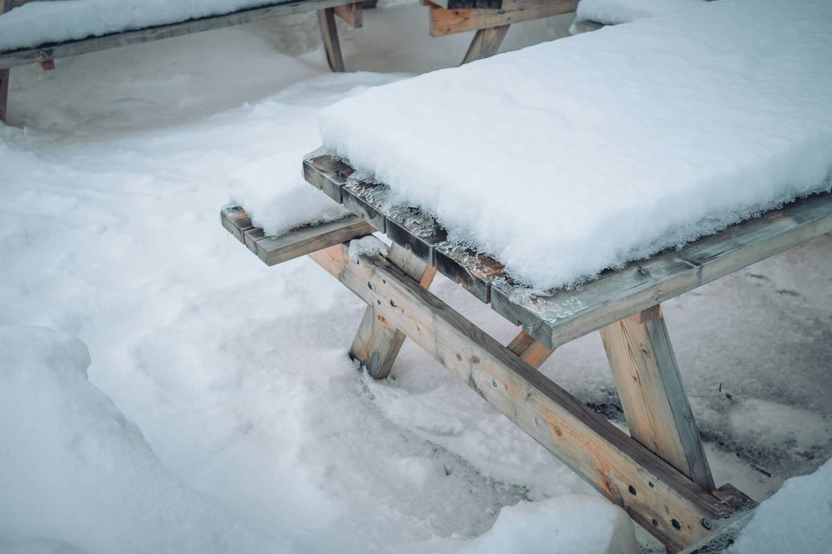 Close-up of a durable fire pit table cover with reinforced stitching and air vents installed on a stone-top fire table