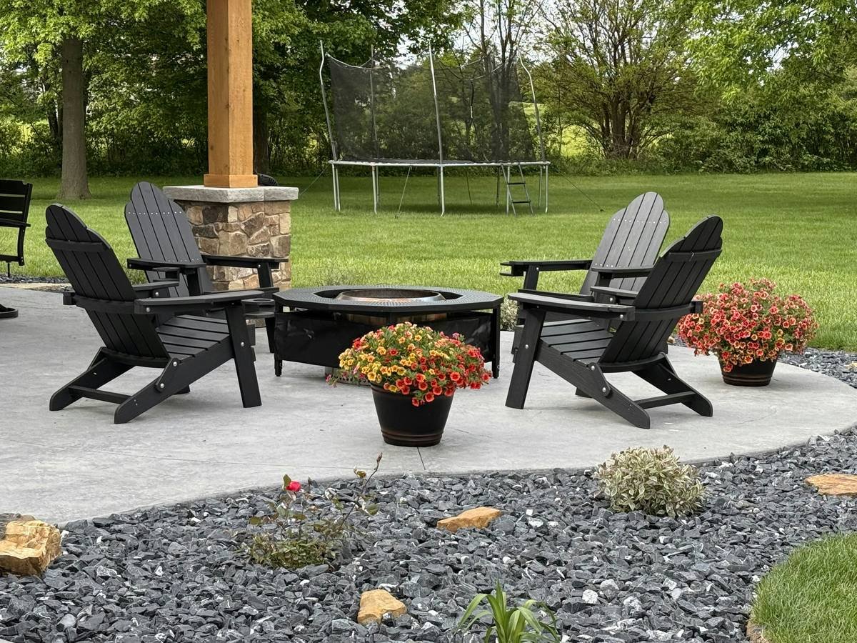 fire pit with chairs arranged in a semi-circle around a stone fire bowl, showing safe distance and heat-resistant materials